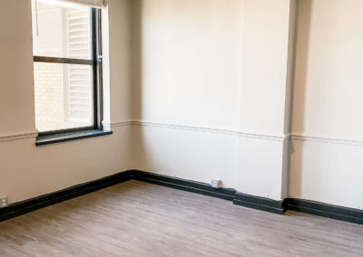 View of an Empty Room with a Ceiling Fan at Merchants Plaza Apartments