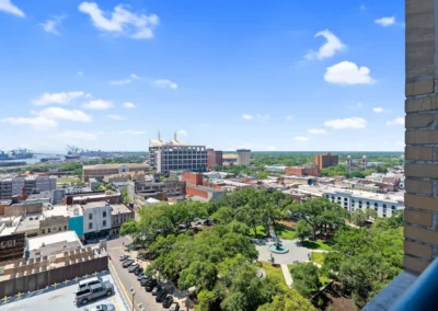 Aerial view of a cityscape with buildings, trees, and blue sky with clouds on a bright sunny day at Merchants Plaza.